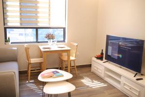 海防Lee Apartment & Hotel的客厅配有电视和桌椅