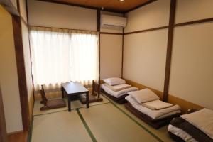 富士河口湖Yoshimura ooike sense的客房设有两张床、一张桌子和一扇窗户。