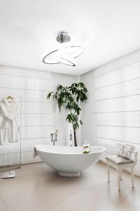 锡耶纳Residenza d'Epoca Palazzo Borghesi的一间带白色浴缸和植物的浴室