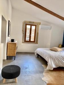 尼姆Grand confort au cœur de Nîmes的一间卧室配有一张床、一张桌子和一个窗户。