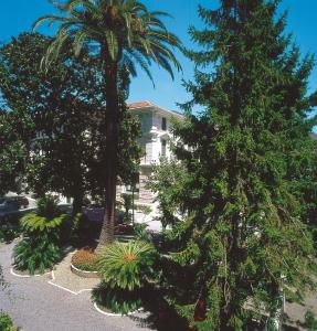 瓦拉泽Genovese Villa Elena Residence的院子里两棵棕榈树的房子
