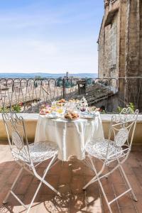 锡耶纳Residenza d'Epoca Palazzo Borghesi的阳台上摆放着食物盘的桌子
