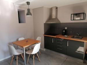 贡多马尔Green Villas Douro的厨房配有木桌和白色椅子