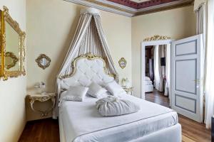 锡耶纳Residenza d'Epoca Palazzo Borghesi的一间卧室配有一张带天蓬的白色床