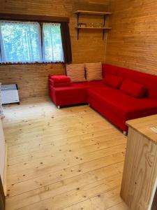 ZdislavaChata Petrofka的铺有木地板的客房内的红色沙发