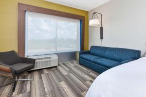 大急流城Holiday Inn Express & Suites - Grand Rapids Airport - South, an IHG Hotel的酒店的客房 - 带一张床、椅子和窗户