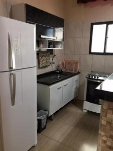 蒙加瓜Apartamento no Centro de Mongaguá的厨房配有白色冰箱和水槽