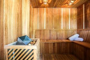 巴拉奈里奥-坎布里乌Praia do Estaleiro Guest House的一间铺有木地板的桑拿浴室,设有木墙