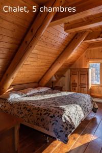 尚博尔拉圣让Spa小木屋的木制阁楼卧室配有一张床