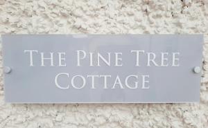 DromodThe Pine Tree Cottage of Warren Lodge Boutique Cottages的松树小屋墙上的标志