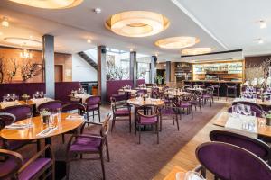 利托米什尔阿普朗斯酒店的餐厅设有木桌和紫色椅子