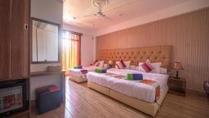 古雷德胡Rosy Villa Hotel的酒店客房设有两张床和电视。