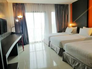 罗勇罗勇胡德里斯酒店的酒店客房设有两张床和电视。