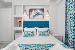斯卡拉伯塔麦斯Foti's Villas的一间卧室配有蓝色床头板和一张带枕头的床