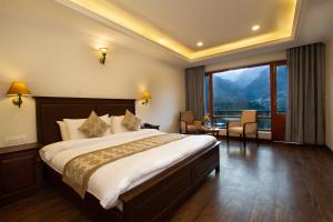 马拉里Aloka Resort的一间卧室设有一张大床和一个大窗户