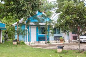 Ban Phon Thong穆恩维花园城镇旅馆的一座棕榈树的蓝色房子