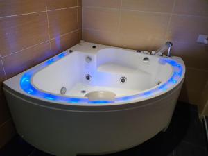 马六甲Grandeur Hotel And Spa的浴室内配有带蓝色灯光的浴缸。