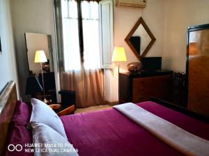 罗马Suite 59 romeholidayhome的一间卧室配有一张带紫色床单的床和窗户。