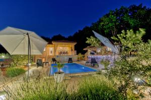 奥米沙利Villa Sole的一座带游泳池和遮阳伞的房子