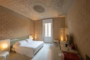 曼托瓦Scaravelli Residenza的卧室配有白色的床和格子天花板
