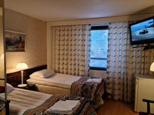 锡林耶尔维Hotelli Sandels的酒店客房设有两张床和一台平面电视。