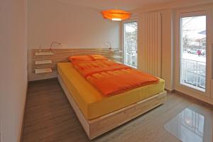 迪格滕兰德格斯霍夫赫尔森酒店的一间卧室配有一张带橙色毯子的大床