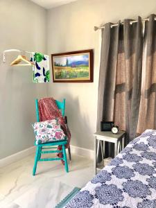 迈阿密Colorful and Luminous Suite near MIA - 4G的卧室配有蓝色椅子,位于床边