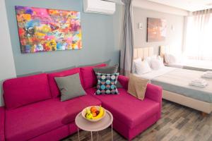 雅典Ermou Downtown Studios by Hospitality Box的客厅配有粉红色的沙发和床。