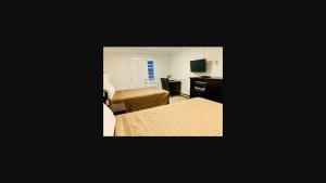 彭蒂克顿彭蒂克顿汽车旅馆的酒店客房带两张床、一张书桌和一间卧室
