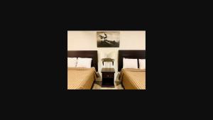 彭蒂克顿彭蒂克顿汽车旅馆的卧室配有两张床,墙上挂着一幅画