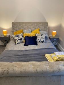 滨海圣安娜Cambridge Villas Private Studio Lytham St Annes的一间卧室配有一张大床,提供黄色和蓝色的枕头