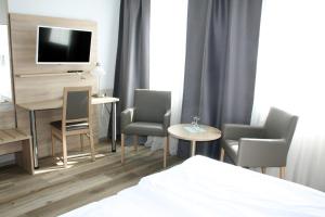 纽伦堡呃林斯特艮酒店的酒店客房配有床、椅子和电视。