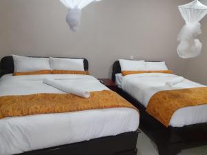 布兰太尔Delight Lodge的两张带橙色和白色床单的床