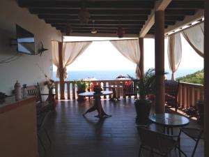 Playa EstacahuiteGloria's Hotel的一位在门廊上散步的海景女性