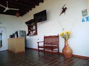 Playa EstacahuiteGloria's Hotel的花瓶和椅子的房间