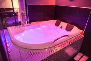 鲁昂L'Espace Privé Rouen的带浴缸的浴室,配有紫色照明