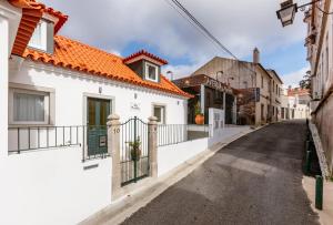 辛特拉Vila Município, "Urban Chic", Sintra的一条有白色房屋和橙色屋顶的街道