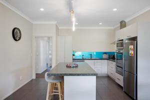 怀希比奇Sky Blue Retreat - Waihi Beach Holiday Home的厨房配有白色橱柜和台面