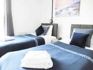 伍尔弗汉普顿Queen Street Apartments的客房内的两张床和毛巾