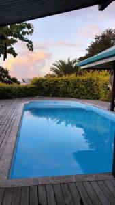 乌图罗阿Villa U'upa的木制甲板旁的大型蓝色游泳池