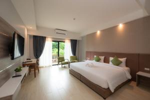 坤西育府Phumontra Resort Nakhon Nayok的酒店客房设有一张大床和一台电视。