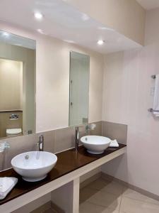 坎诺克Roman Way Hotel的一间带两个盥洗盆和大镜子的浴室