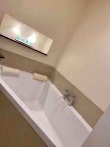 坎诺克Roman Way Hotel的浴室配有带水槽的大浴缸