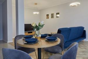 大波兰地区奥斯特鲁夫Luksusowy Apartament的一间带桌子和蓝色椅子的用餐室