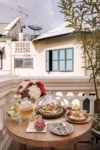 曼谷The Knight House Bangkok的阳台上摆放着食物盘的桌子