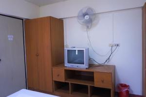 清迈水井宾馆的客房设有带风扇的梳妆台和电视机。