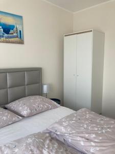 大波兰地区奥斯特鲁夫Luksusowy Apartament的一间卧室配有床和白色橱柜