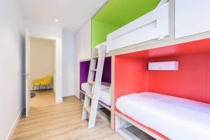 圣塞瓦斯蒂安BUENPAS的一间卧室设有两张双层床,拥有色彩缤纷的墙壁