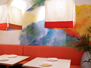 慕尼黑第一克里提夫大象酒店的餐厅里两张桌子,墙上有五彩缤纷的墙