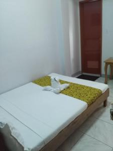 塔比拉兰Bohol Coop Tourist Inn的一间卧室配有一张带白色床单和黄色毯子的床。